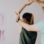 crop osteopath checking up arm joint of unrecognizable female patient