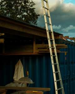a ladder leaning up against a blue building