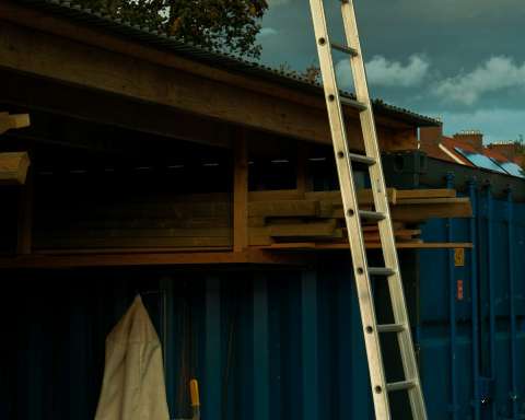 a ladder leaning up against a blue building