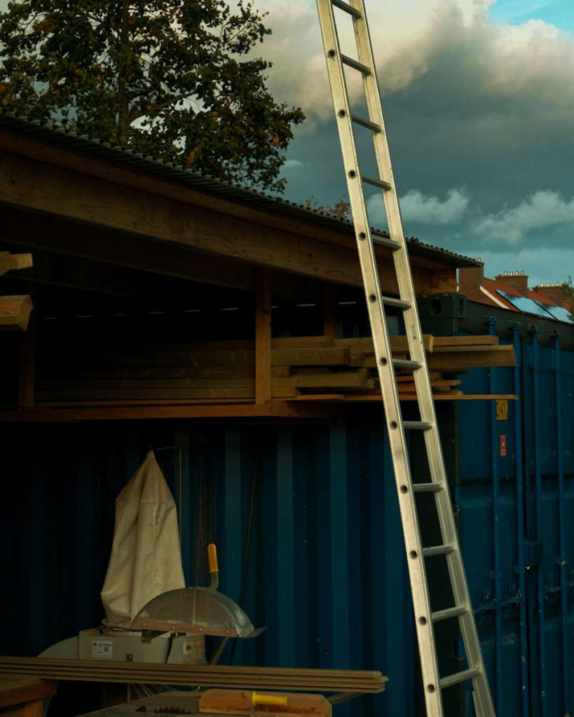 a ladder leaning up against a blue building