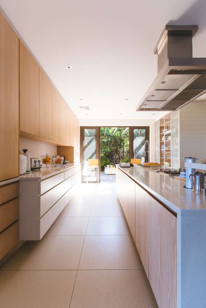 white wooden kitchen island and cupboard cabinets near glass panel door