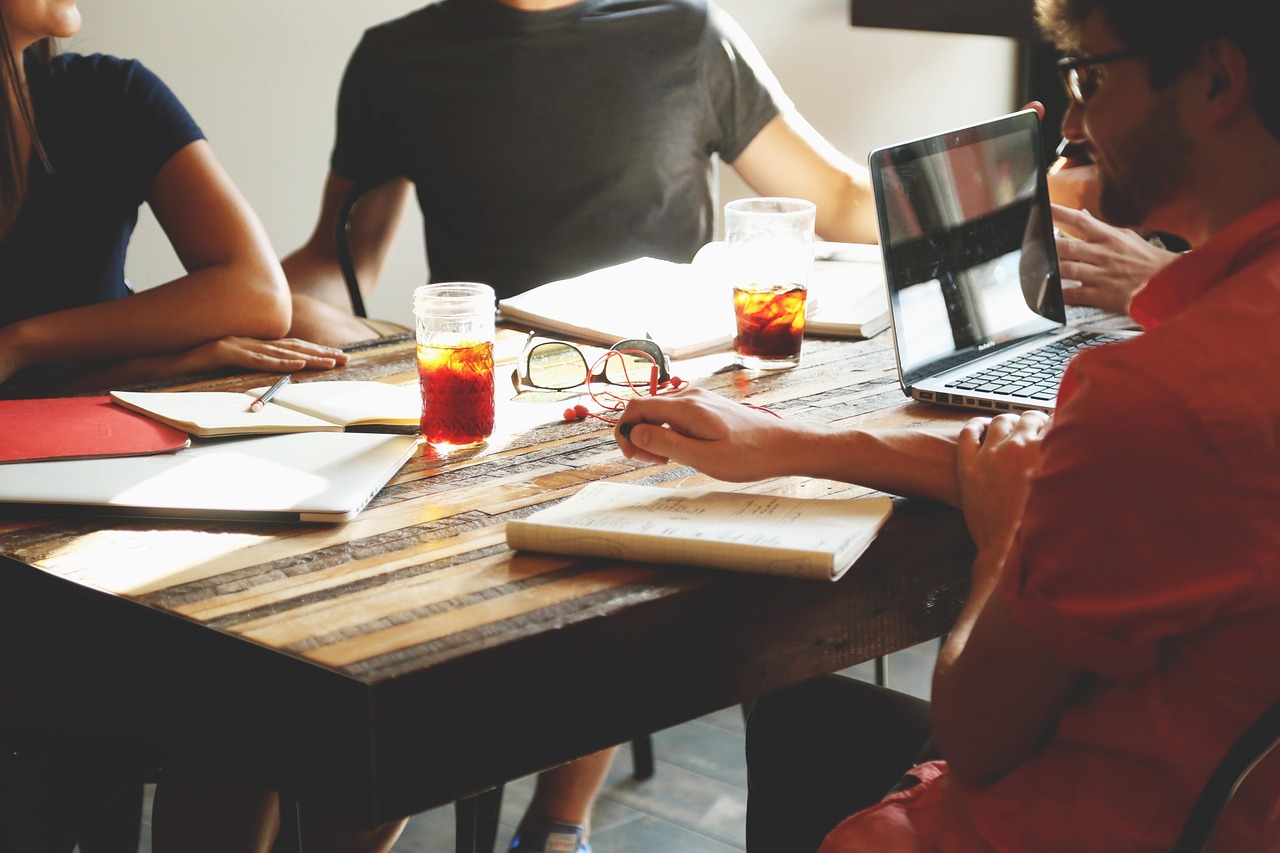 IT-projectmanager in overleg met teamleden rond een laptopscherm op kantoor