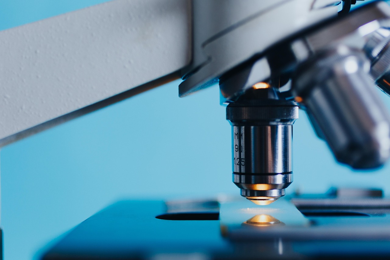 Medisch laboratoriumtechnoloog die werkt aan een microscoop in een klinisch laboratorium