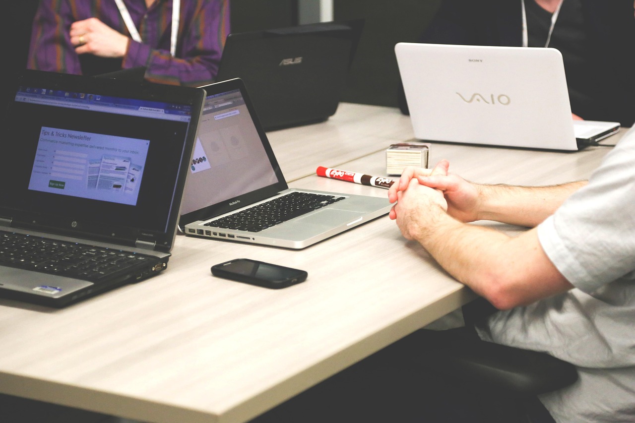 Team in een modern tech kantoor werkt samen aan laptops